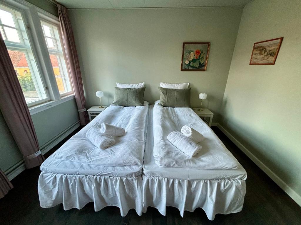 海斯勒Hotel Kysten的一间卧室配有带白色床单和枕头的床。