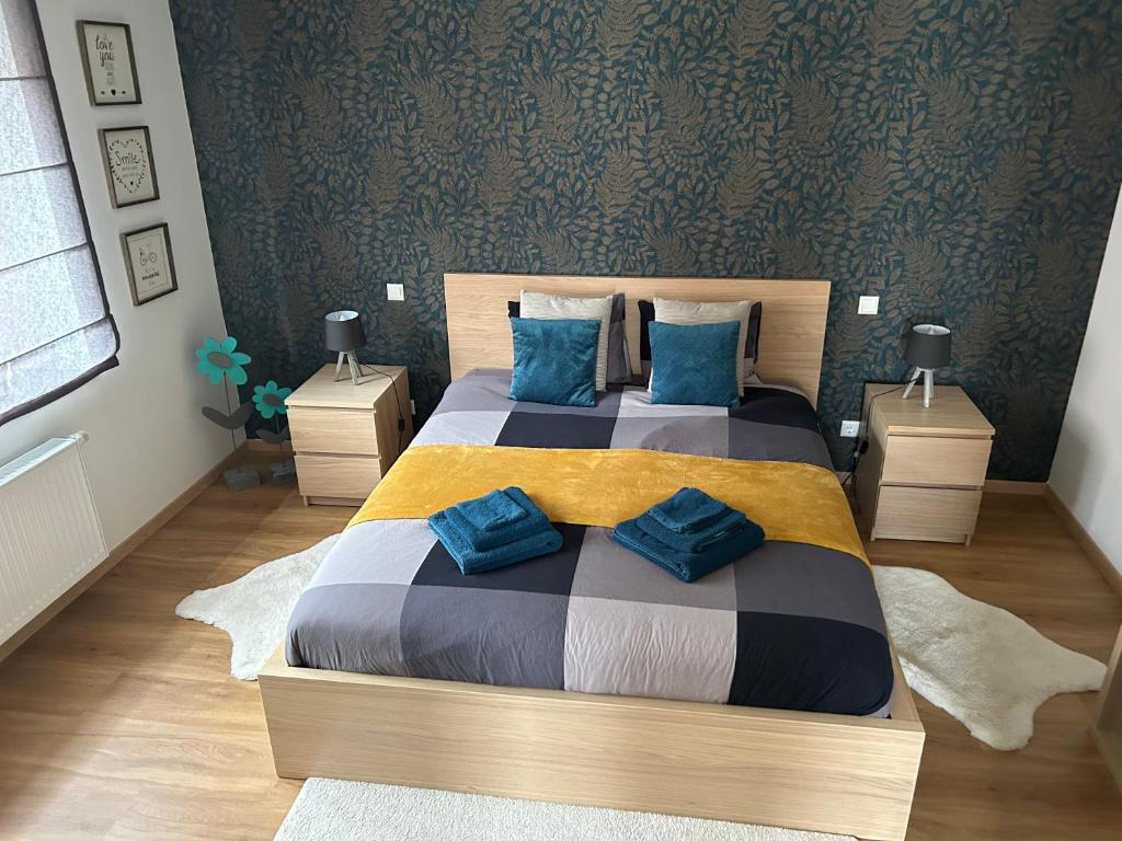 EischenLe cocon de Céline的一间卧室配有一张带蓝色枕头的大床