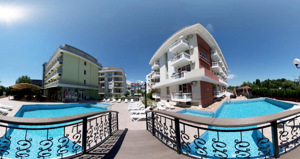 阳光海滩扎拉酒店的一座带两个游泳池和大楼的度假村