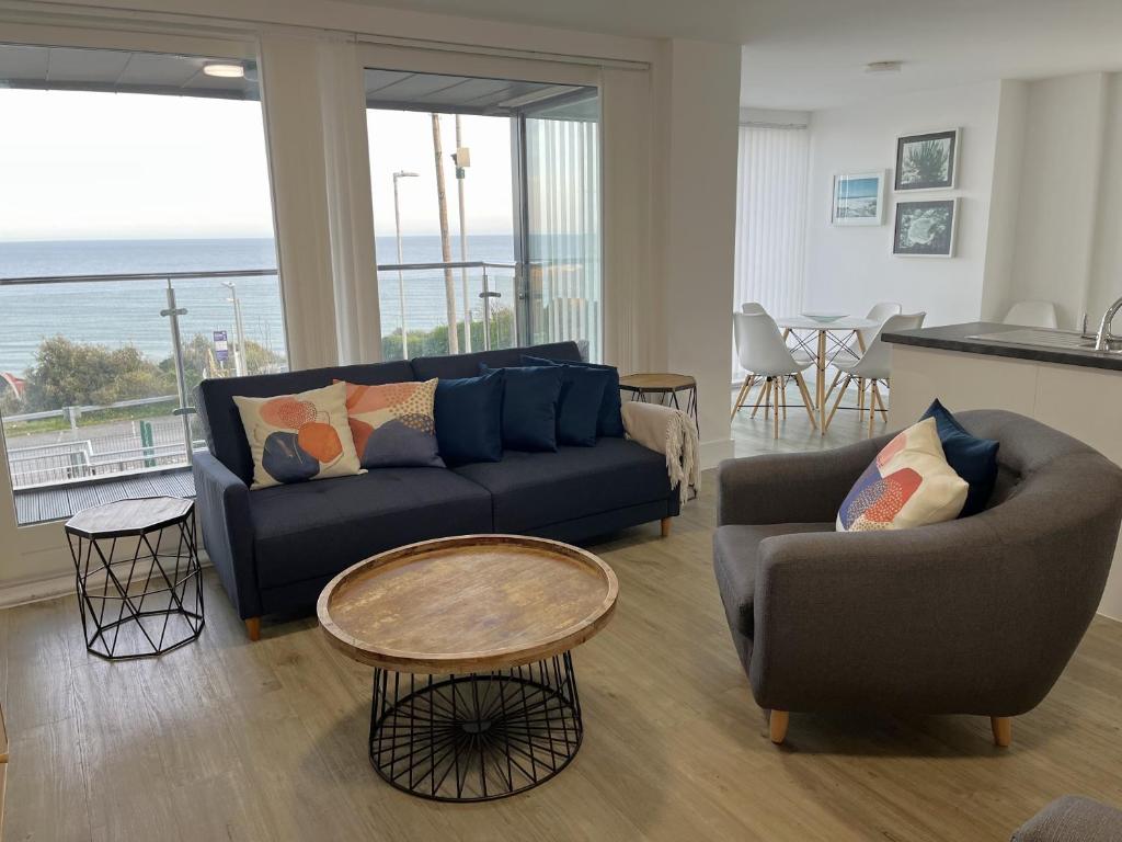 伯恩茅斯Seaview West Coast的客厅配有沙发、椅子和桌子