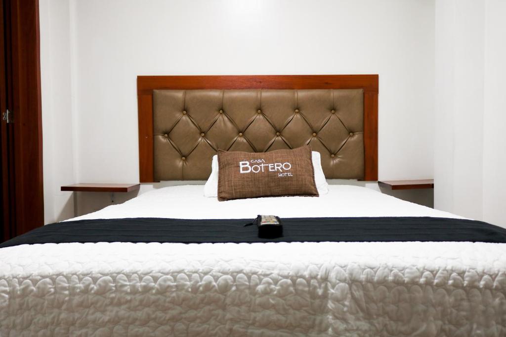 波哥大Hotel Casa botero 106的床上有棕色枕头