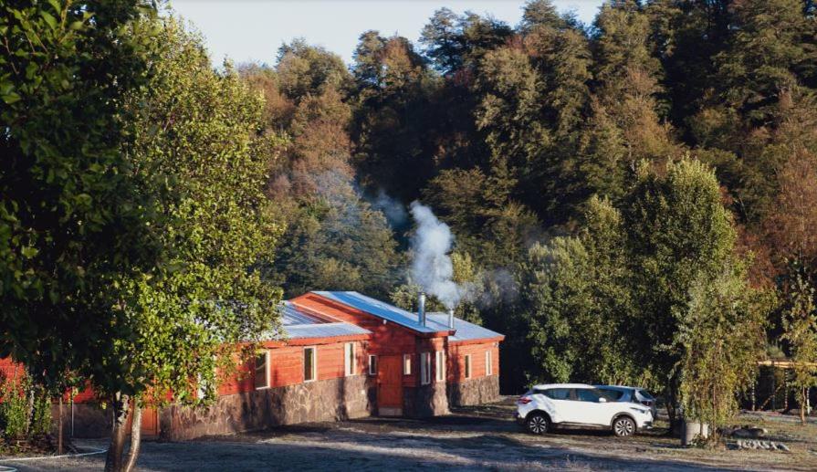 库拉考廷Cabañas & Hostal Lefuco的停在红色建筑前面的白色汽车