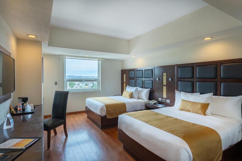 普埃布拉Comfort Inn Puebla Centro Historico的酒店客房设有两张床和窗户。