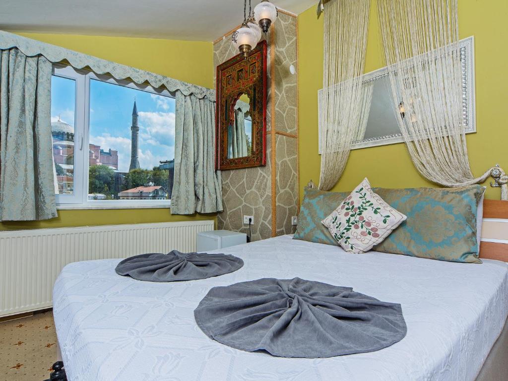 伊斯坦布尔现代苏丹酒店的一间卧室配有一张带两个灰色枕头的床