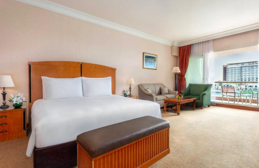 阿布扎比Al Raha Beach Hotel - Gulf View Room SGL - UAE的酒店客房设有一张大床和一个阳台。