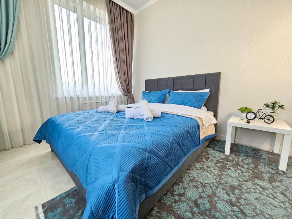 阿拉木图ЖК ATREA 2 room Apartment的一间卧室配有蓝色的床和毛巾