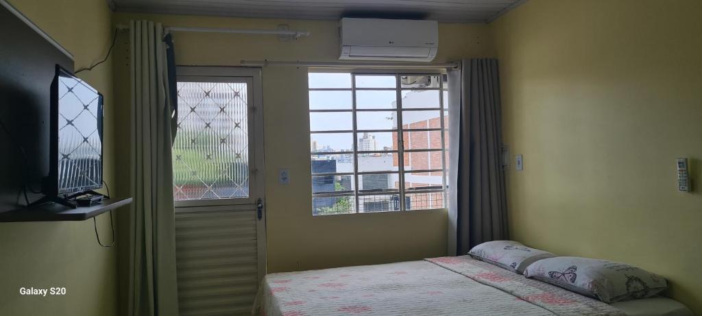 沙佩科Loft Confortável no Centro的一间卧室设有一张床和一个美景窗户。