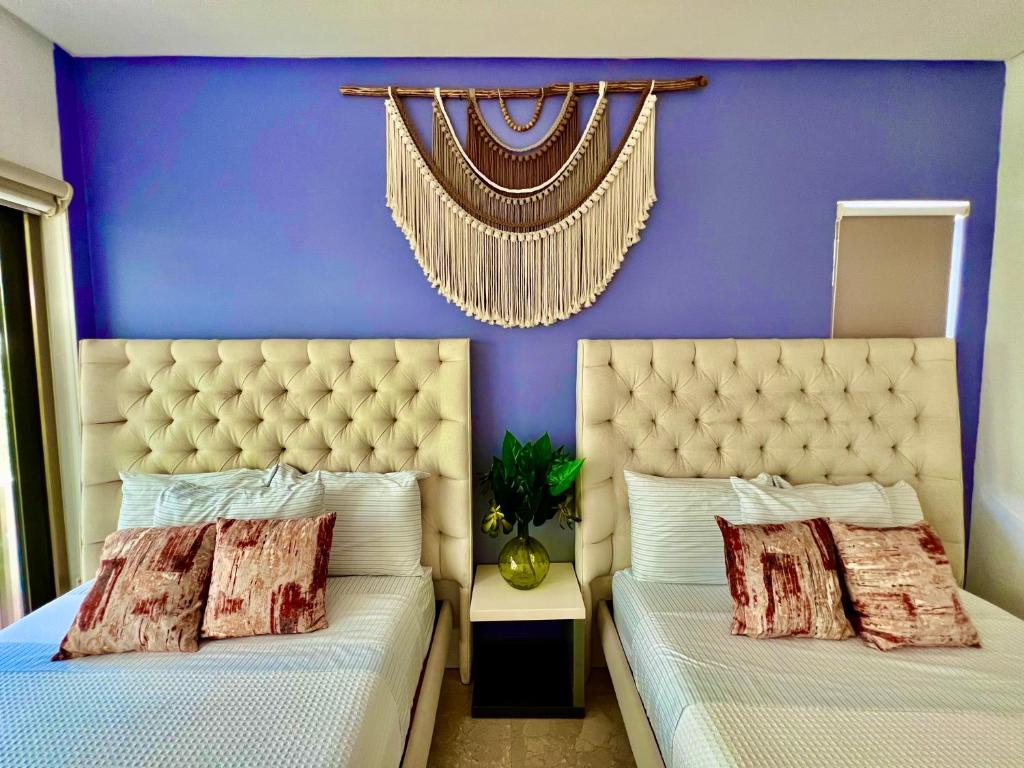 莫雷洛斯港Oceanview Penthouse with Private Pool and Maid Service的卧室设有两张床铺和紫色墙壁