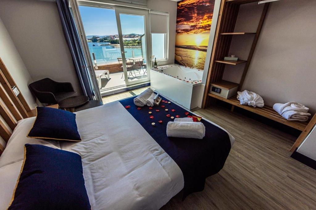 卡马里尼亚斯Playa de Camariñas的一间酒店客房,设有一张大床和一个大窗户