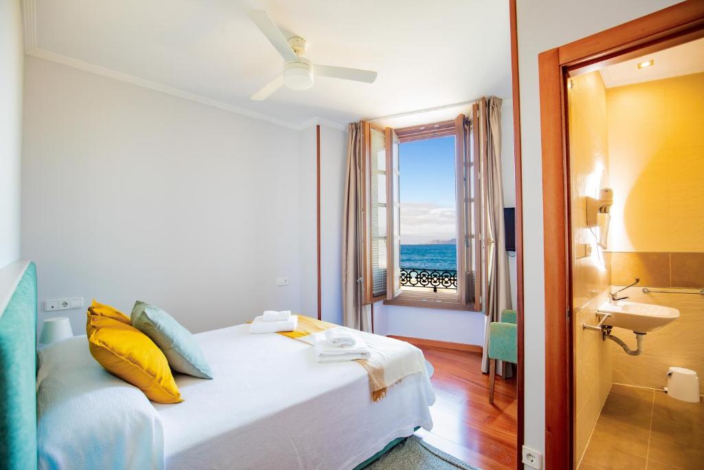 巴约讷Apartamentos Villa Zoila Baiona的一间卧室设有一张床,享有海景