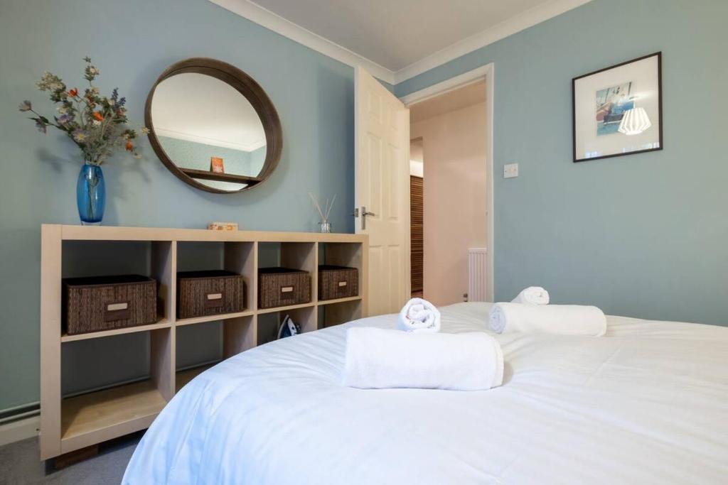 布莱顿霍夫Quiet & calm apartment with garden的卧室配有一张带镜子的白色床