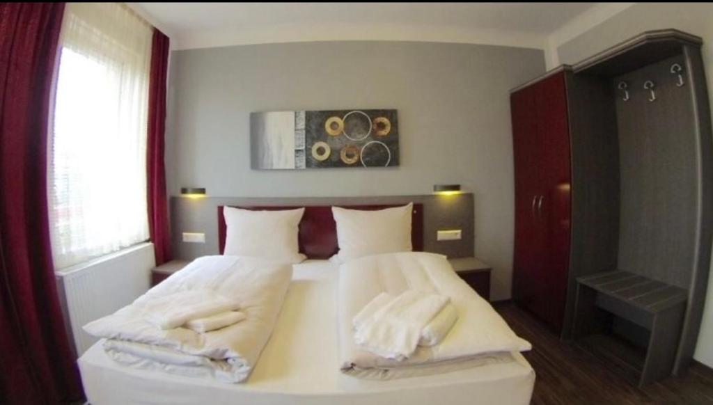 辛德尔芬根Ariston Hotel的一间卧室配有一张床,上面有两条毛巾