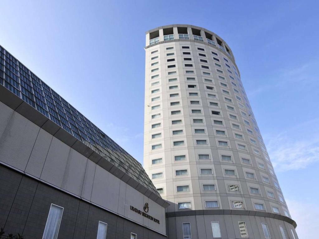 浦安东京湾浦安布莱顿酒店的一座高大的白色建筑,毗邻一座建筑