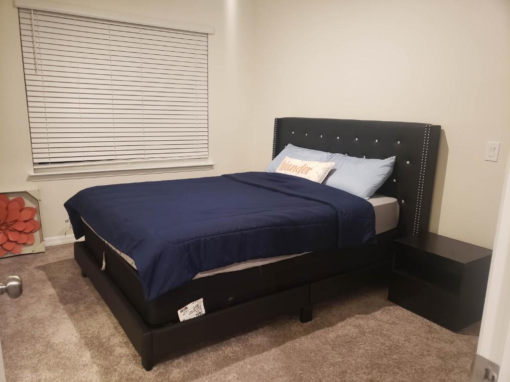 基西米Troy@Kissimme的一间卧室配有一张带蓝色床单的床和一扇窗户。