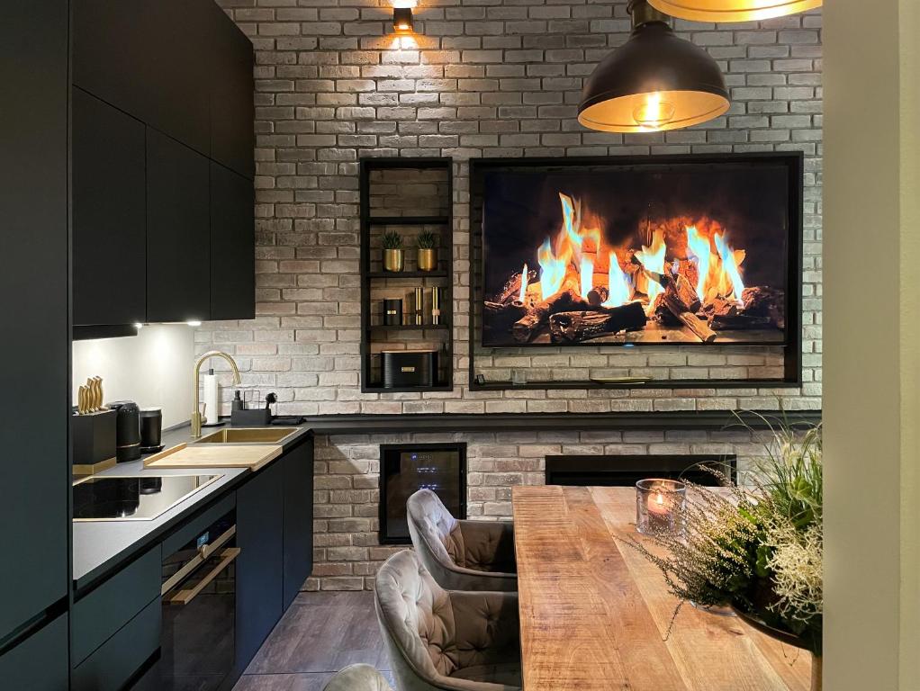 汉堡Black Suite Luxus in Alsternähe的厨房前方设有壁炉、木桌