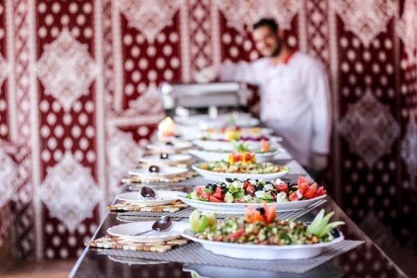 瓦迪拉姆desert wadi rum camp的一张长桌,上面放着食物板