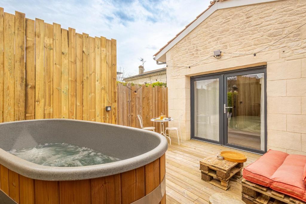 梅里尼亚克Chambres d'hôtes Le Studio Bordelais avec bain nordique的配有木栅栏的庭院内的浴缸