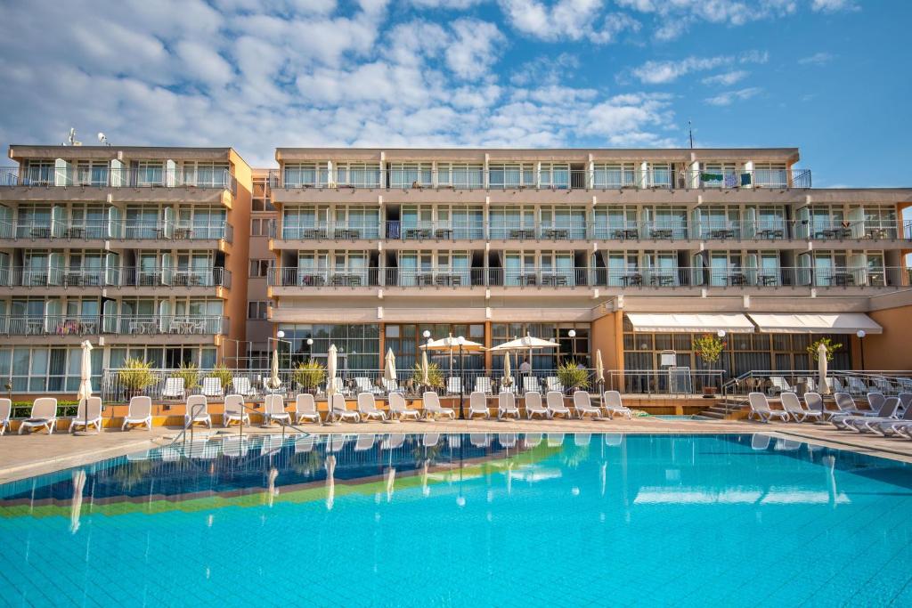 梅杜林Arena Hotel Holiday的一座带游泳池和椅子的酒店和一座建筑