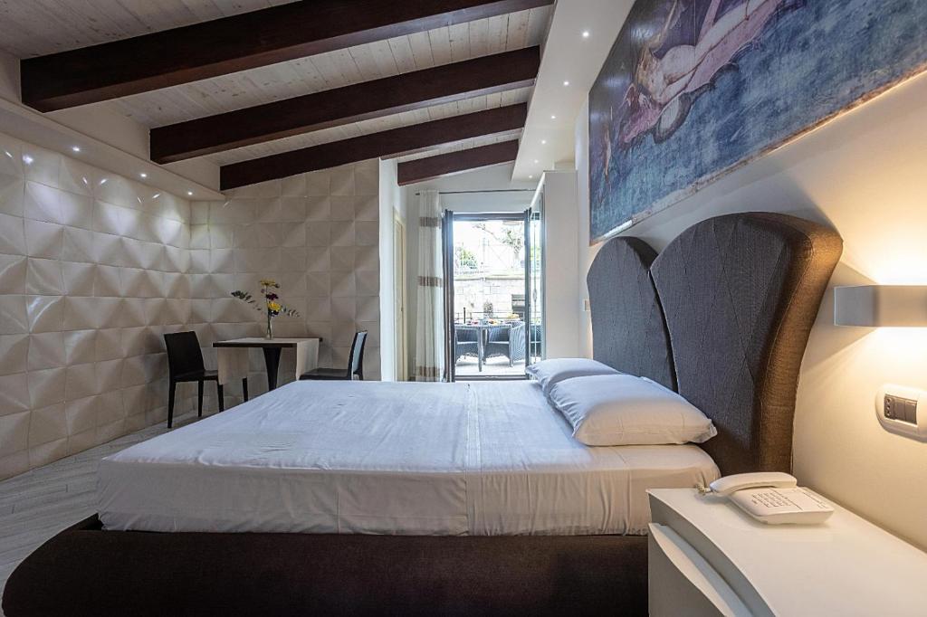 庞贝艾尔伯格庞贝谷酒店的一间卧室配有一张床和一张桌子及椅子