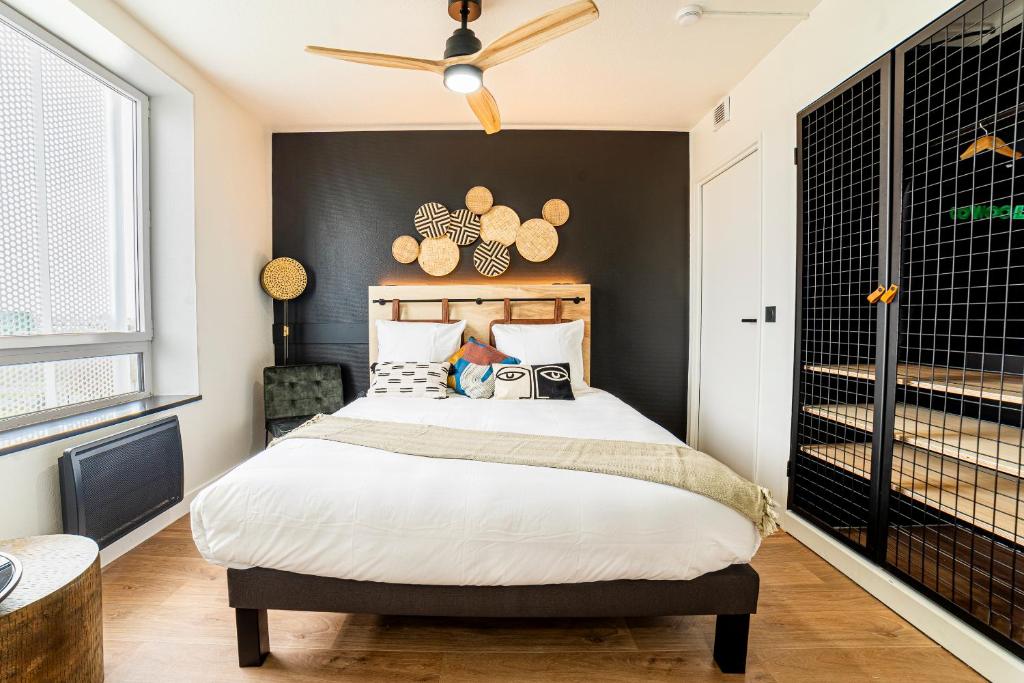 图卢兹COWOOL TOULOUSE的一间卧室配有一张黑色墙壁的床