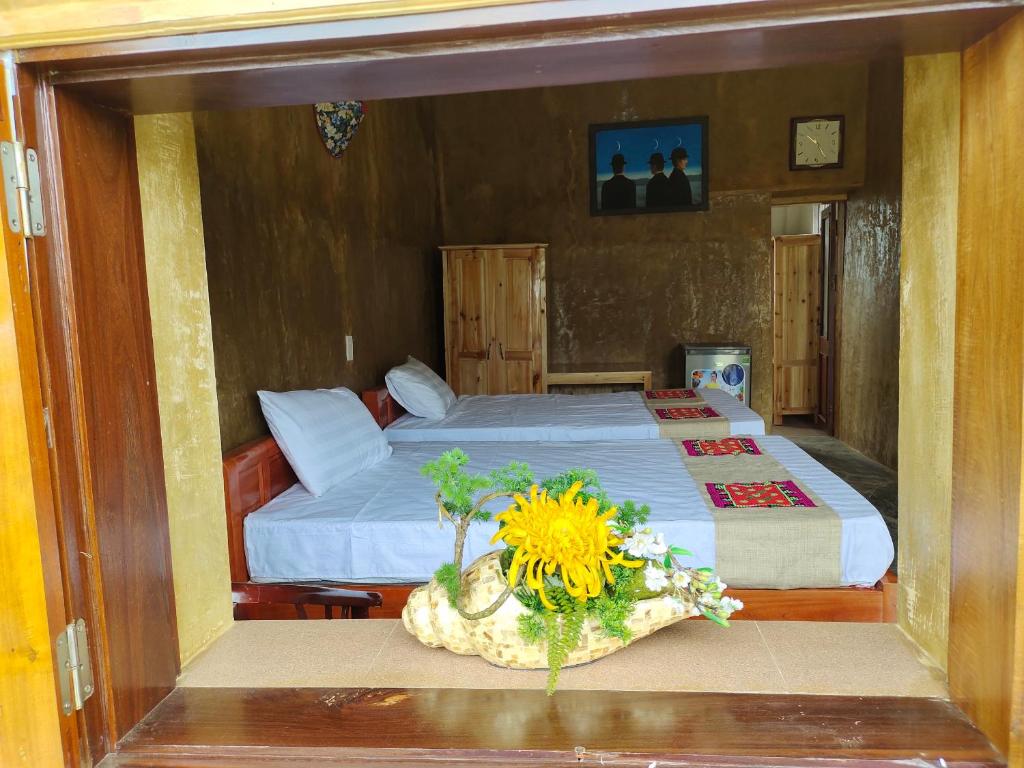 河江Dìn Homestay Nặm Đăm的一间卧室配有一张床,桌子上摆放着向日葵
