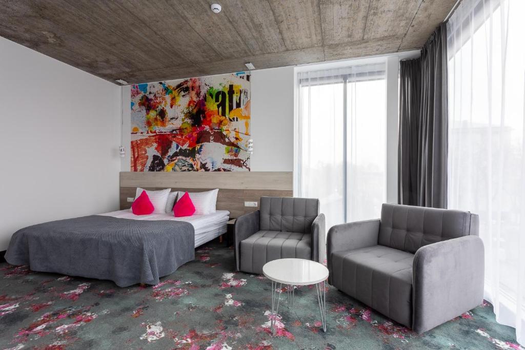 考纳斯阿尔基罗酒店的客厅配有一张床和两把椅子