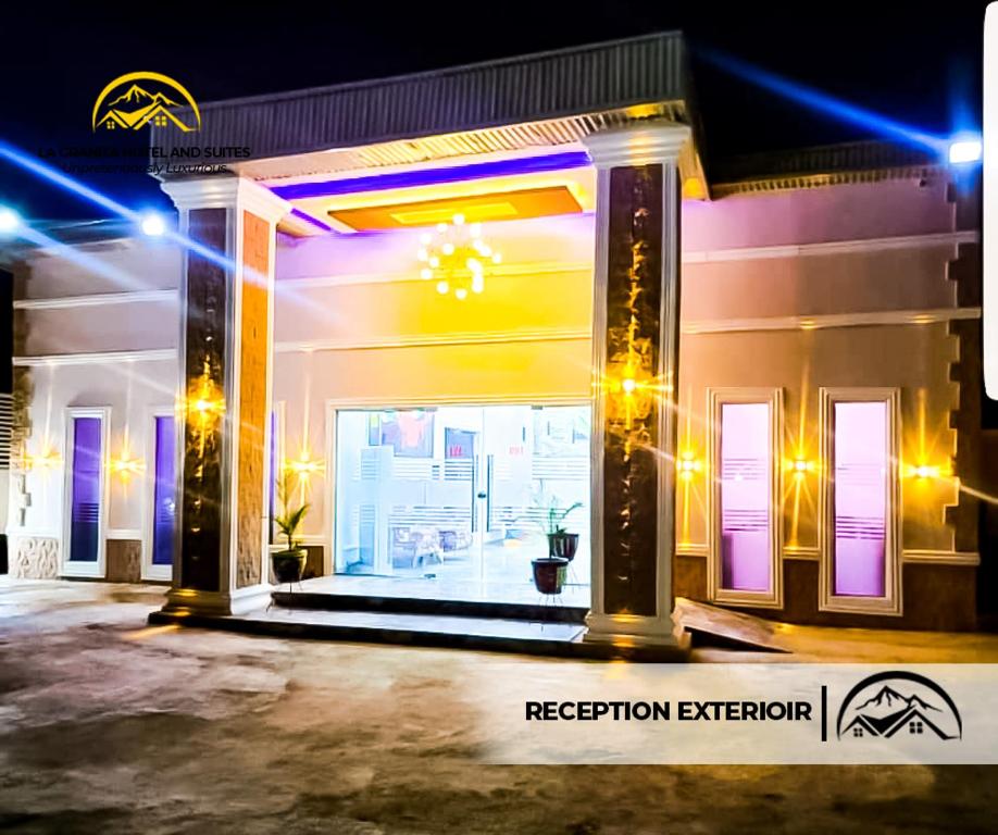 Ado EkitiLA GRANITA HOTEL AND SUITES的一间晚上装有紫色灯的商店