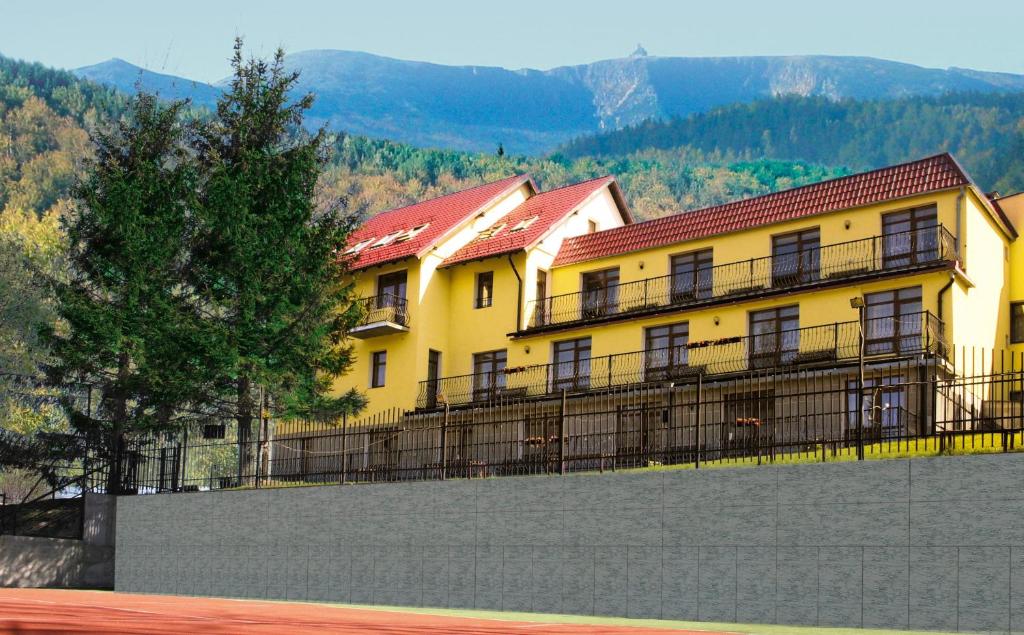 耶莱尼亚古拉-雅戈尼昂库夫Pensjonat Borowik的 ⁇ 顶上带有红色屋顶的黄色建筑