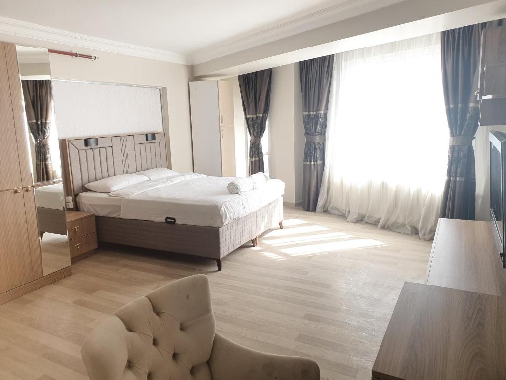 伊斯坦布尔KADIKÖY BRISTOL HOTEL的一间卧室配有一张床、一把椅子和镜子