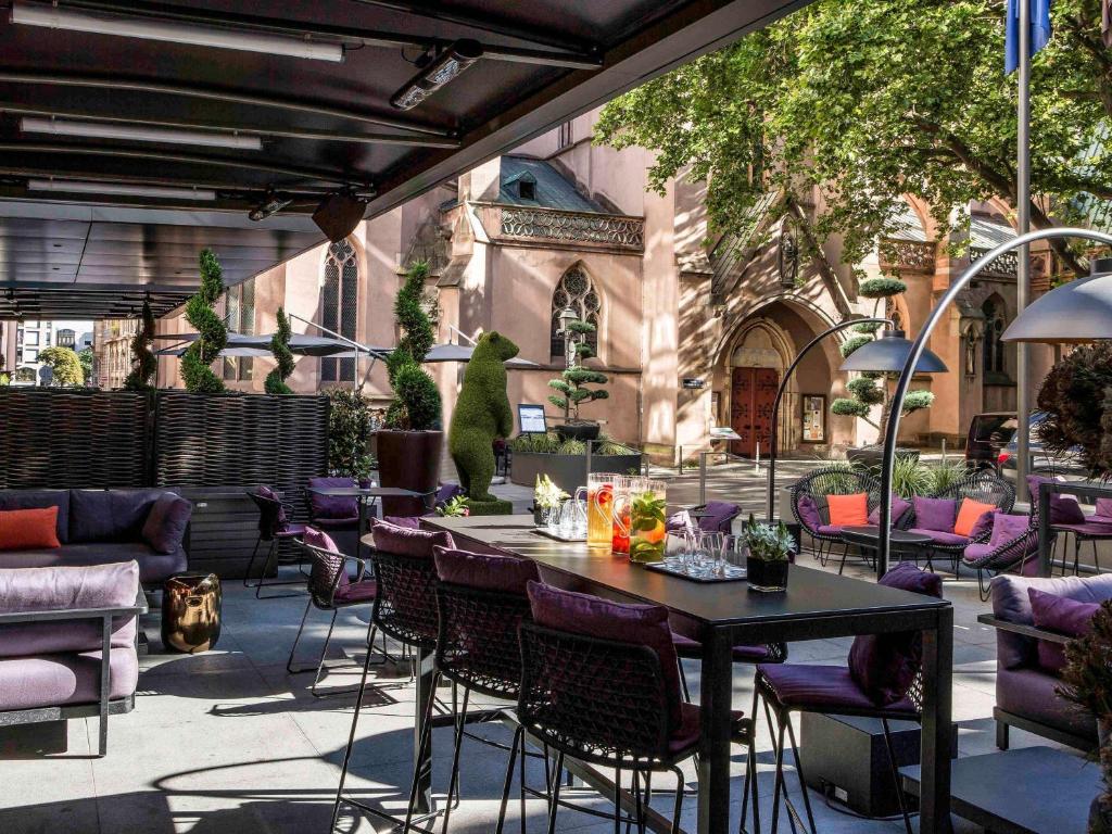 斯特拉斯堡索菲特斯塔伯格格兰德益乐酒店的一个带桌椅的庭院和一座建筑
