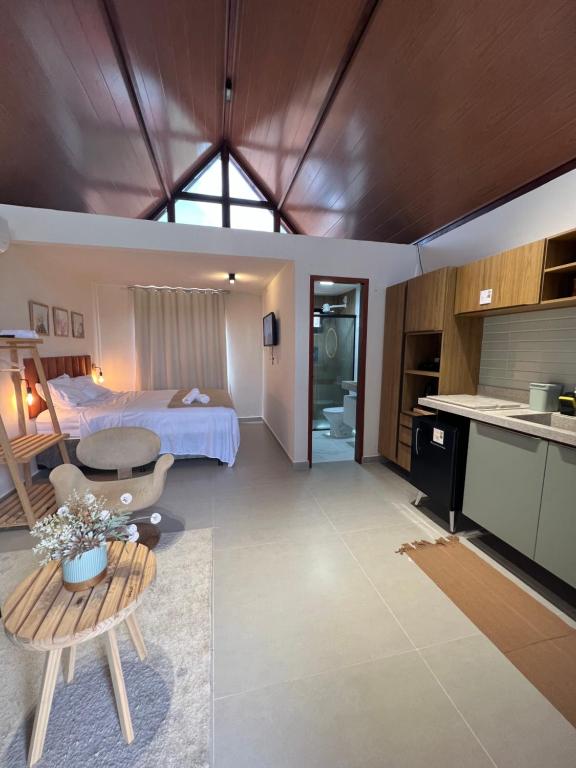 蒙蒂达斯加梅莱拉斯Chalé Monte das Gameleiras/RN的酒店客房设有一张床铺、一张桌子和一间厨房。