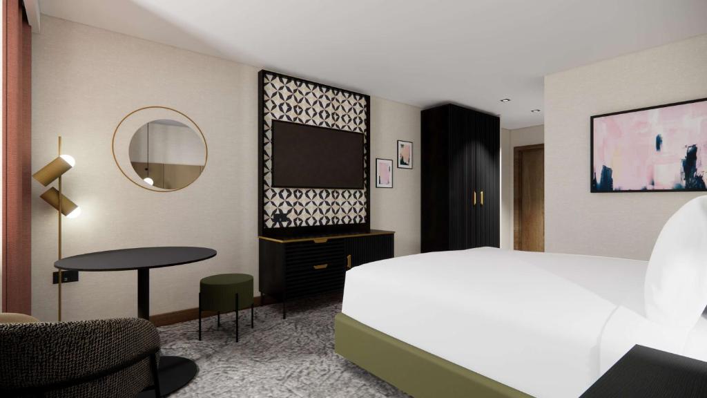 谢菲尔德国敦谢菲尔德酒店的一间卧室配有一张床、一张桌子和一台电视。