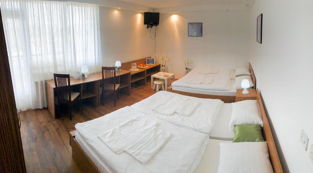 MartjanciRestavracija in prenočišča ČARDA的一间带两张床的卧室和一间带桌子的用餐室