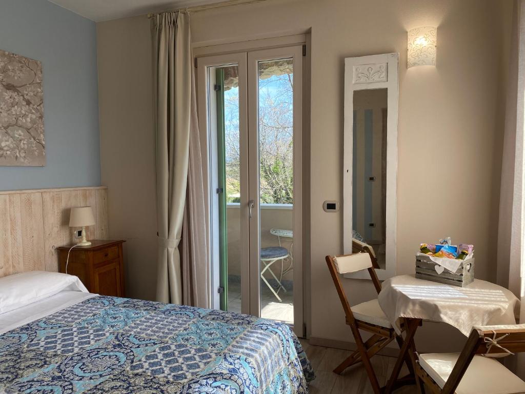 巴多利诺Poggio Bardolino的卧室配有1张床、1张桌子和1把椅子