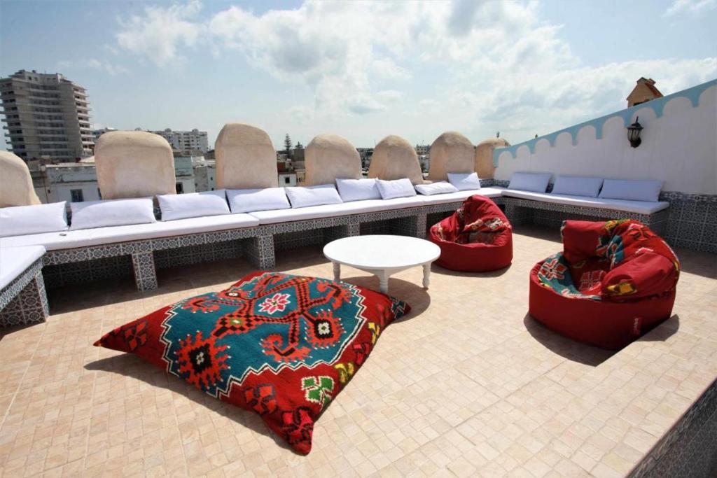 比塞大Dar Sandra Bizerte的屋顶露台配有两把豆椅和一张桌子