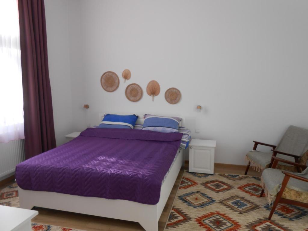 锡比乌盐矿镇Villa Stoia的卧室配有紫色的床和地毯。