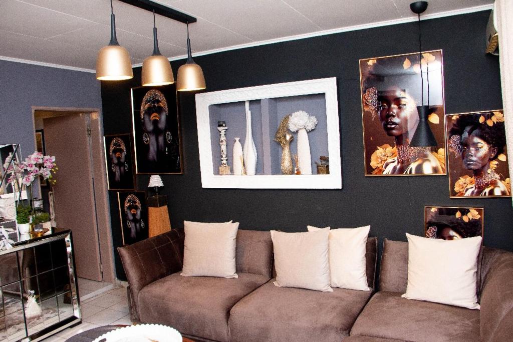 利伯维尔Villa Raissa 2的客厅配有沙发和墙上的照片