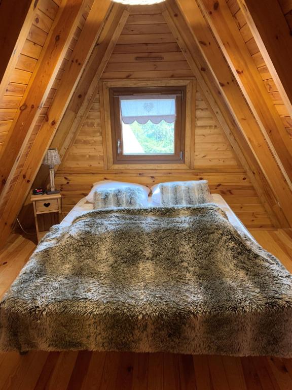 德沃吕伊Chalet 8 à 10 couchages的木制客房内的一张大床,设有窗户