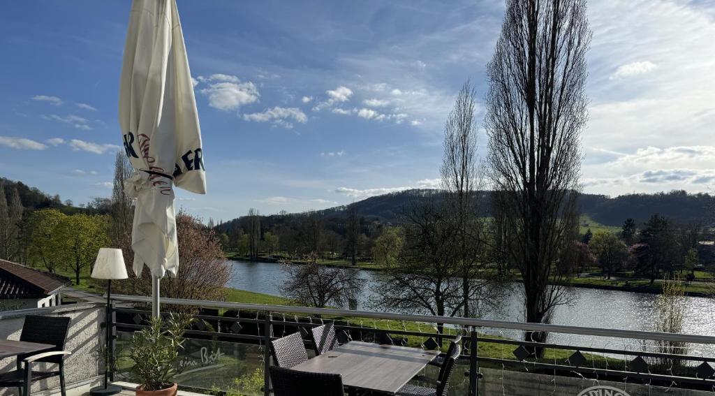 Ralingen拉林根霍夫乡村旅馆的享有河流和遮阳伞景致的天井。