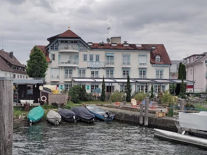 赖兴瑙Hotel Seeschau的一座白色的大建筑,水中有船