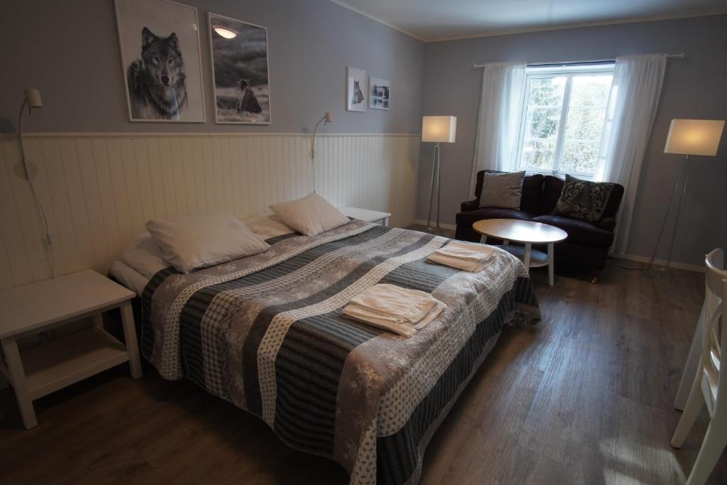 TranstrandMannflogården Bed & Breakfast , Sälenfjällen的卧室配有床、椅子和窗户。