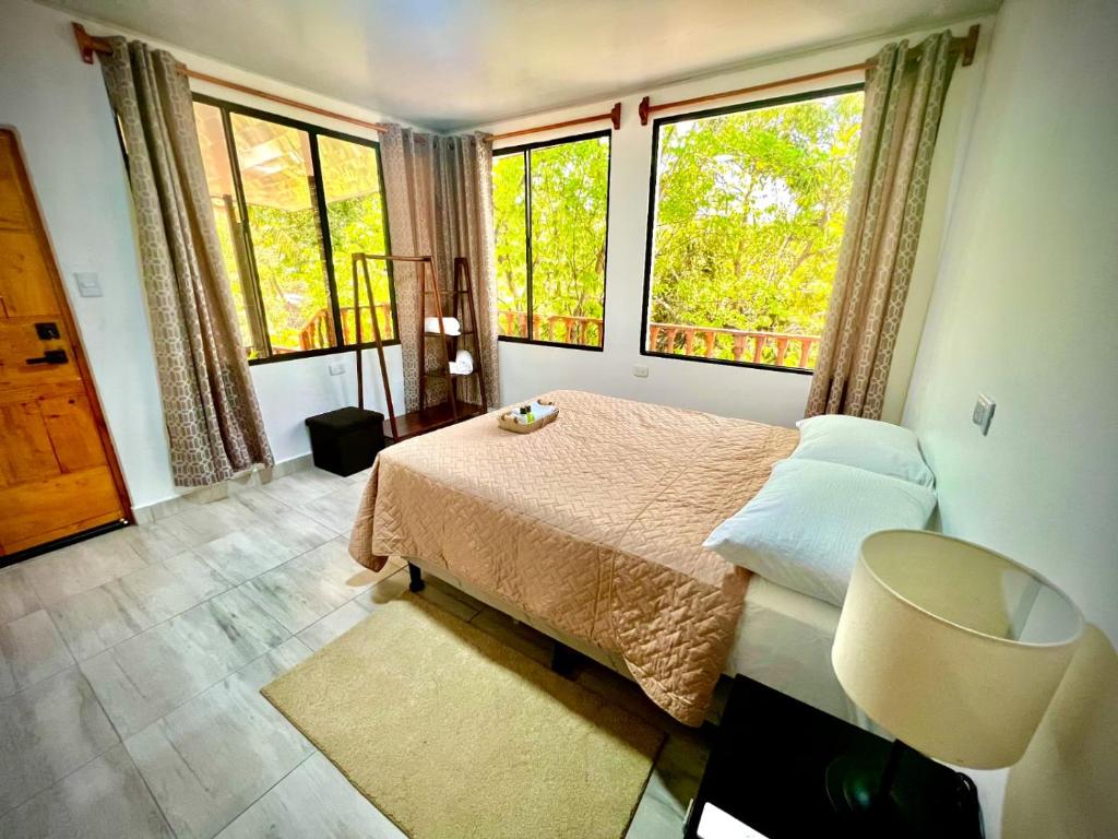 埃尔蒙特Mayara Hostal的一间卧室设有一张床和两个大窗户