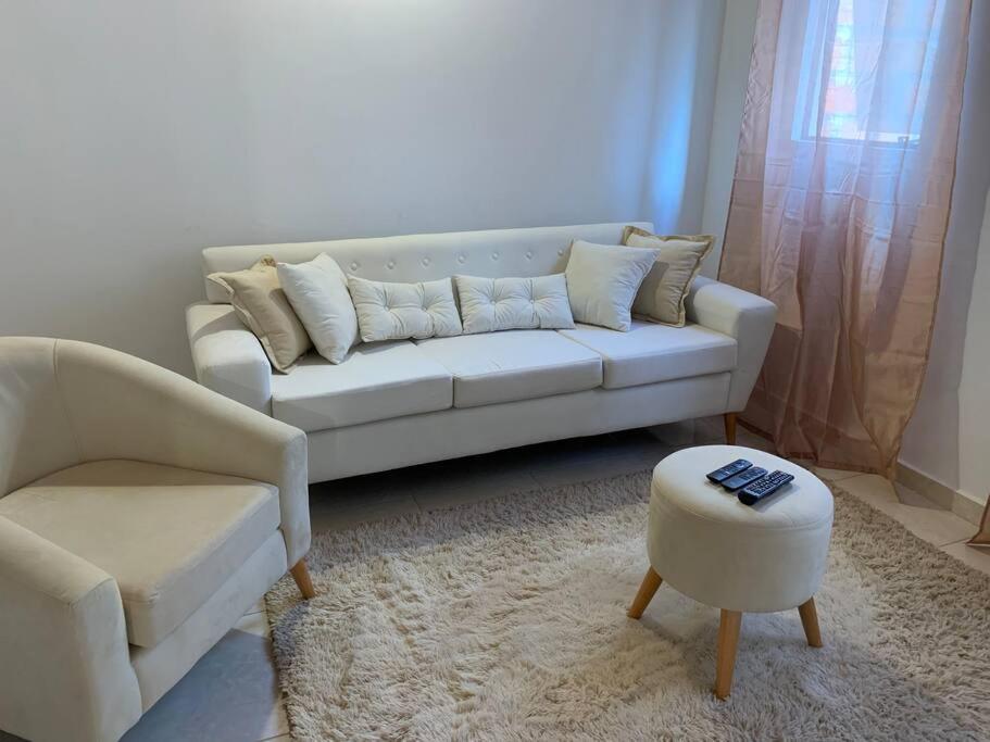 LuqueHermosa casa, zona Aeropuerto的客厅配有白色沙发和凳子