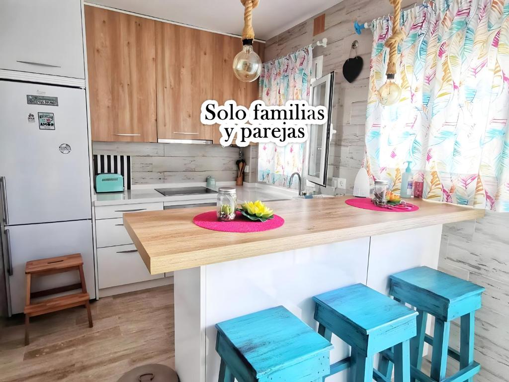 奇克拉纳－德拉弗龙特拉Apartamento Agua marina con terraza的厨房配有带蓝色凳子的木台