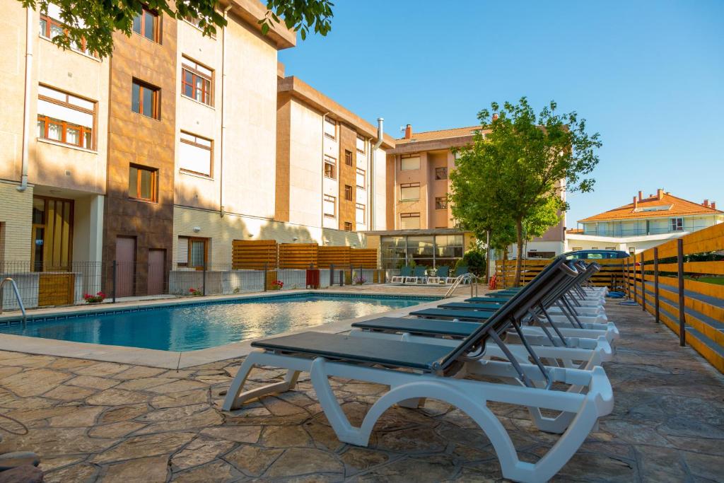 伊斯拉Hotel Los Arces的游泳池旁的一排躺椅