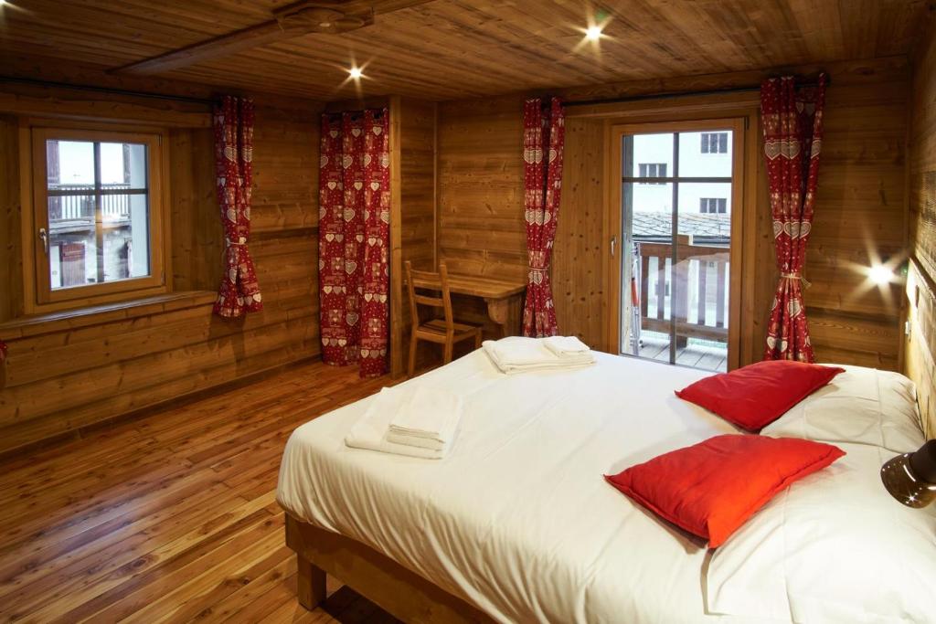 科涅Chalet du Paradis的卧室配有带红色枕头的大型白色床