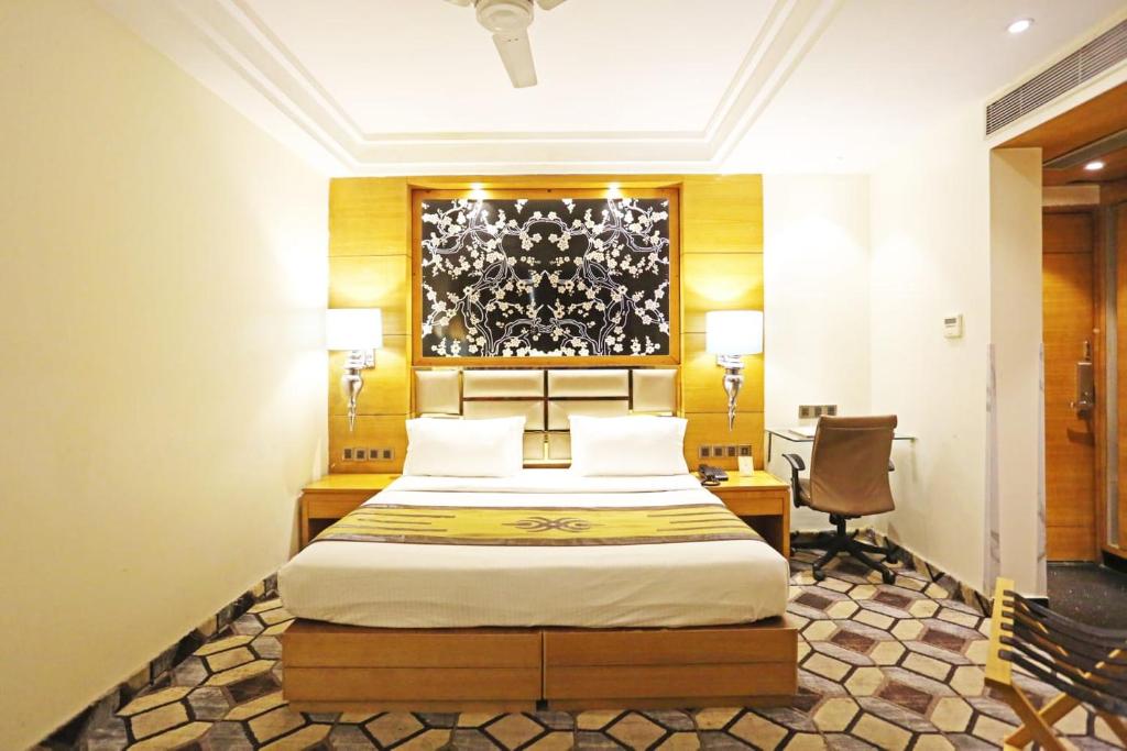 新德里Airport Hotel Claytone的一间卧室配有一张床、一张桌子和一把椅子