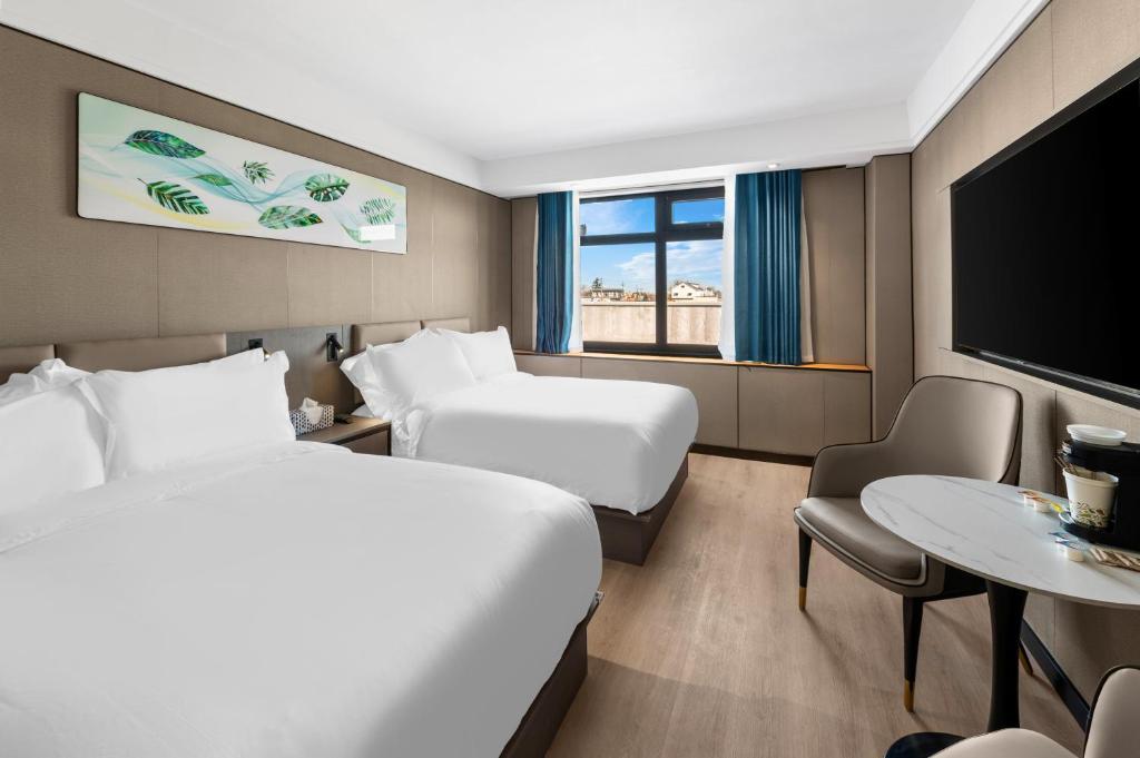 College PointLy New York Hotel的酒店客房设有两张床和一台平面电视。