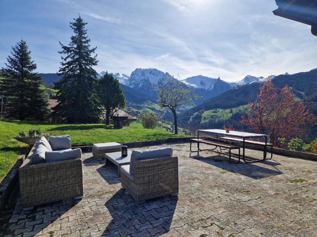 马尼戈Chalet de Manigod的庭院设有两把椅子和一张桌子,享有山景。