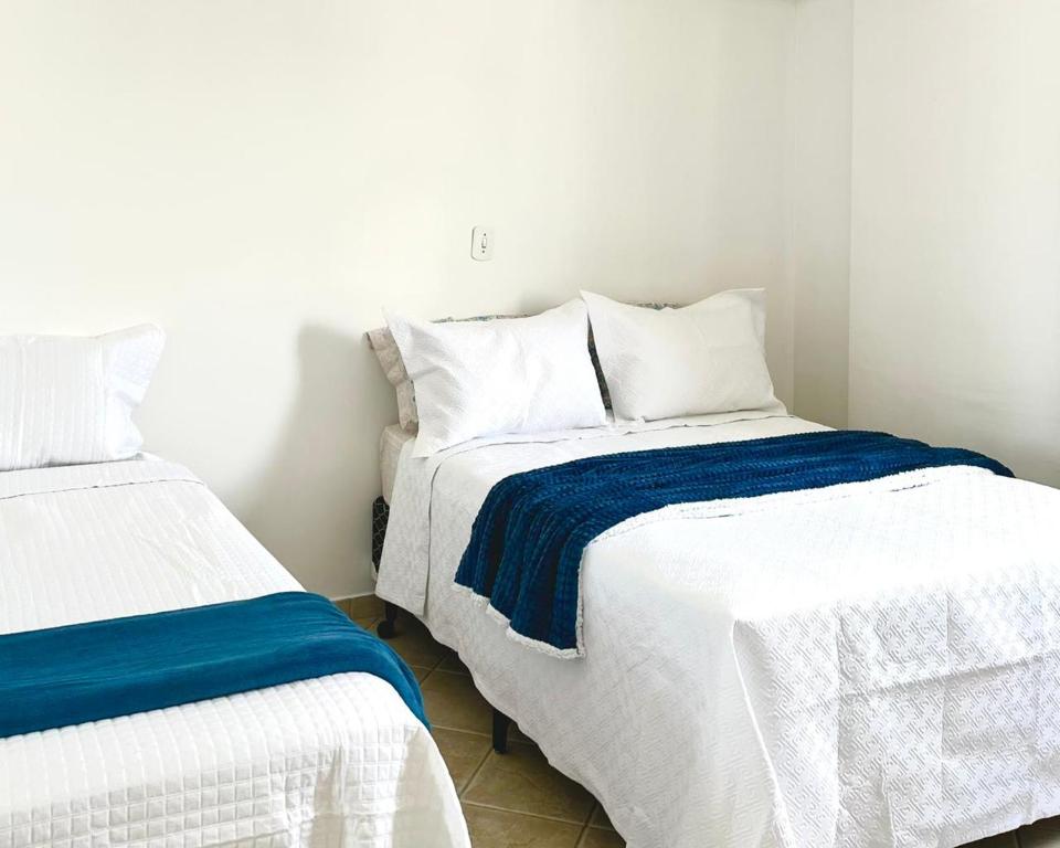 圣若泽杜斯坎普斯Pérola do Aquarius III的一间卧室配有两张带白色和蓝色床单的床